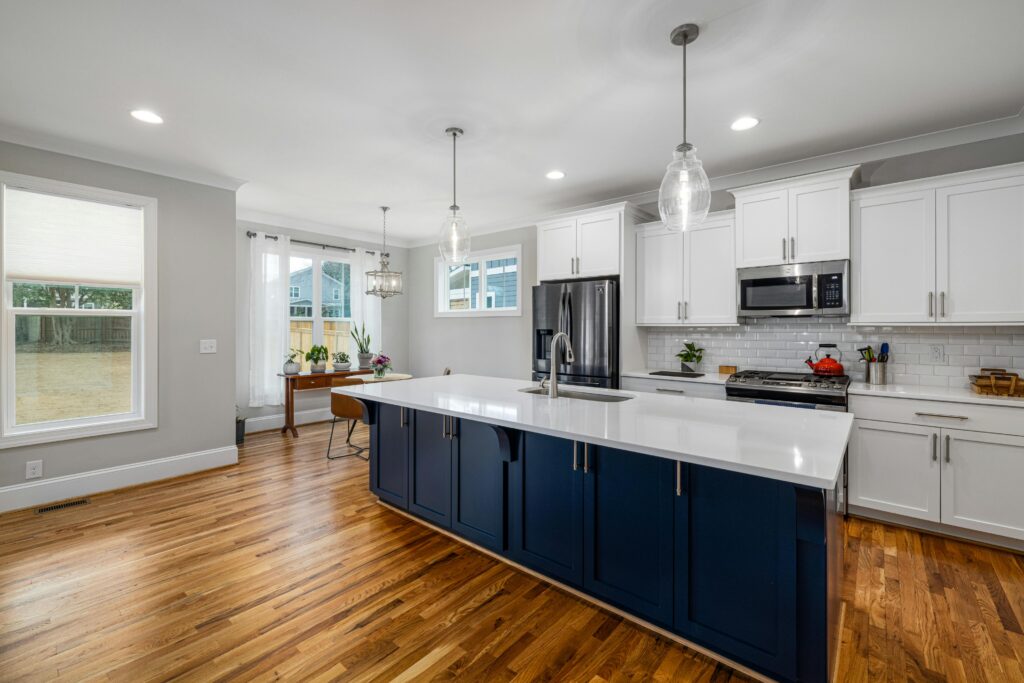 Spacious kitchen featuring white cabinetry and wooden flooring, perfect for modern homes.